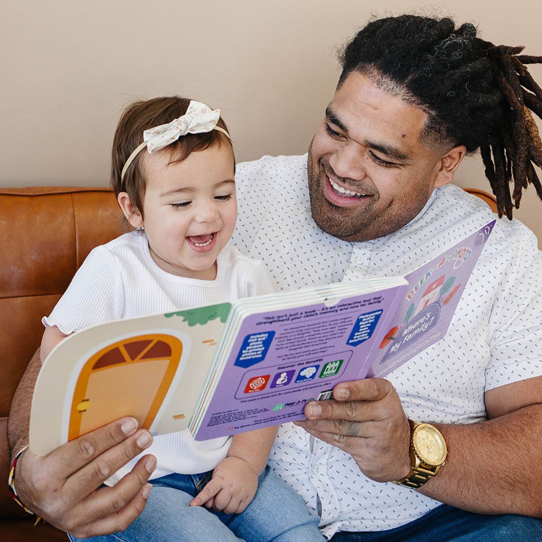 Father and child enjoying Peek-A-Photo lift-the-flap book together at home
