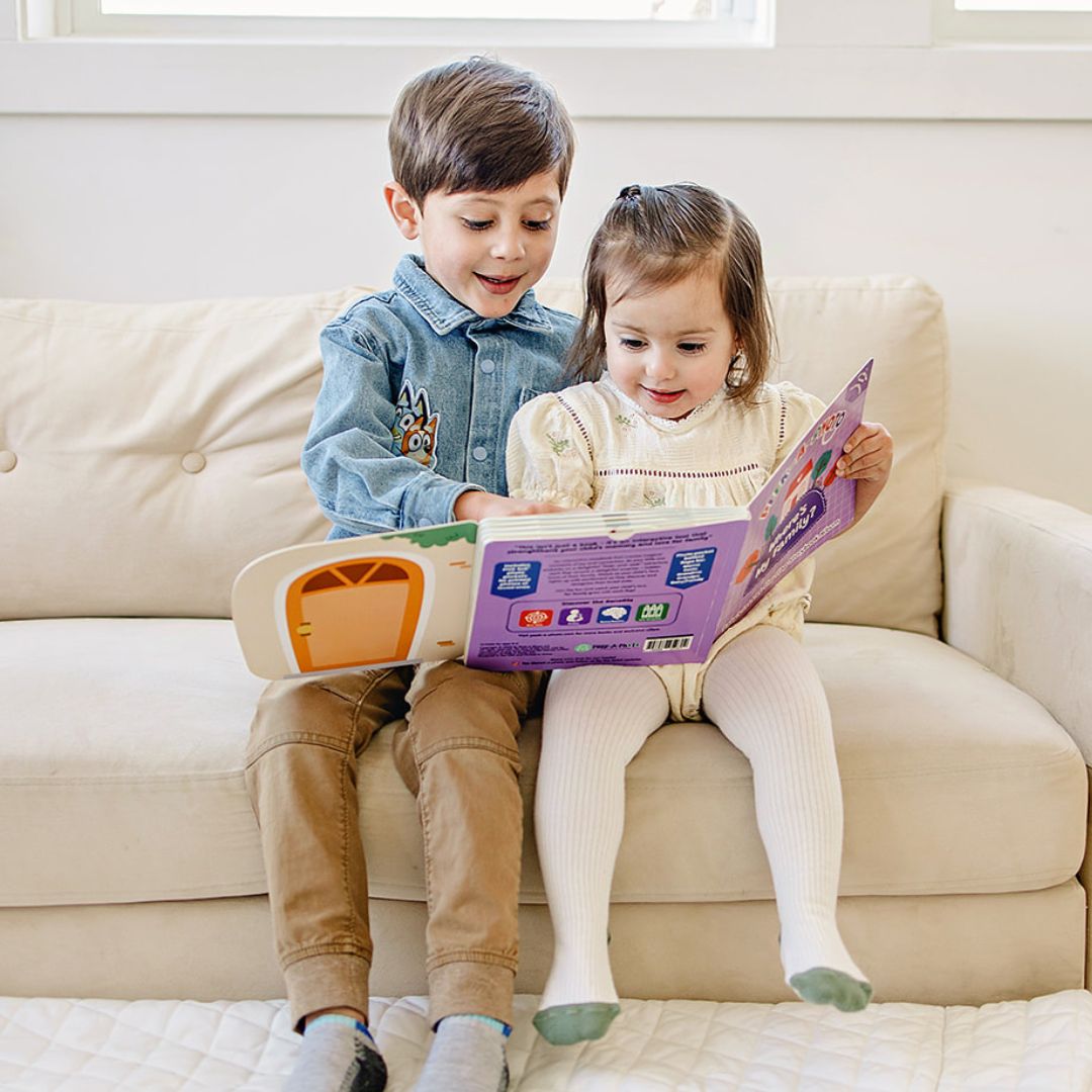Siblings exploring Peek-A-Photo interactive book featuring real photos behind flaps