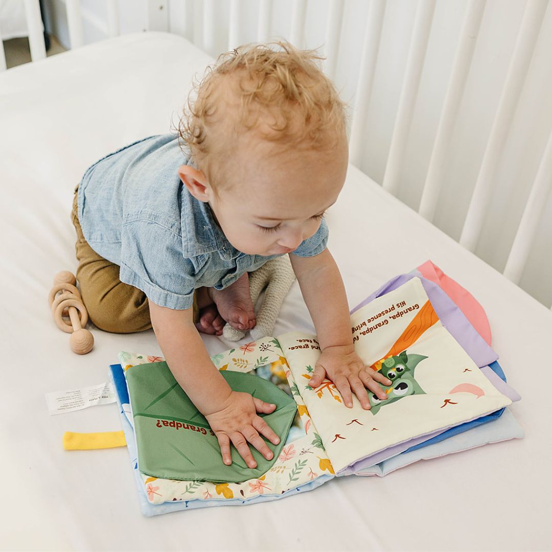 Baby holding Peek-A-Photo's "I Love You" cloth book during sensory play and bonding time