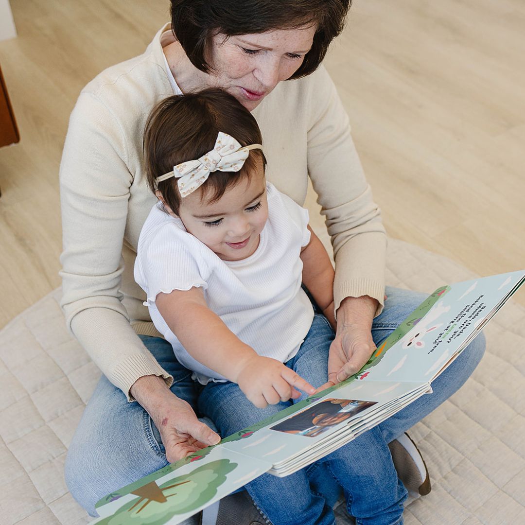 Child playing with grandma while discovering family photos in Peek-A-Photo's personalized photo board book