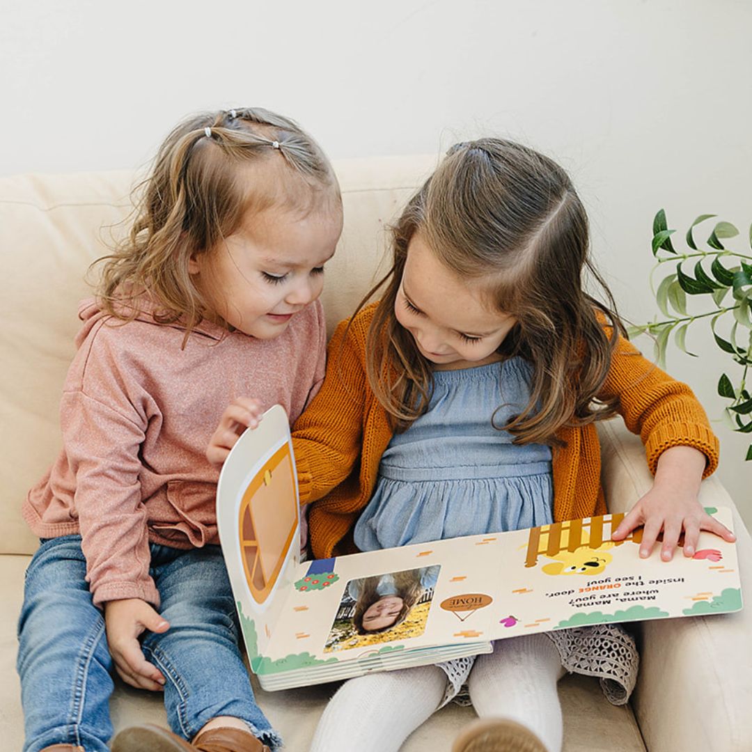 Siblings exploring interactive family photo album with lift-the-flap features